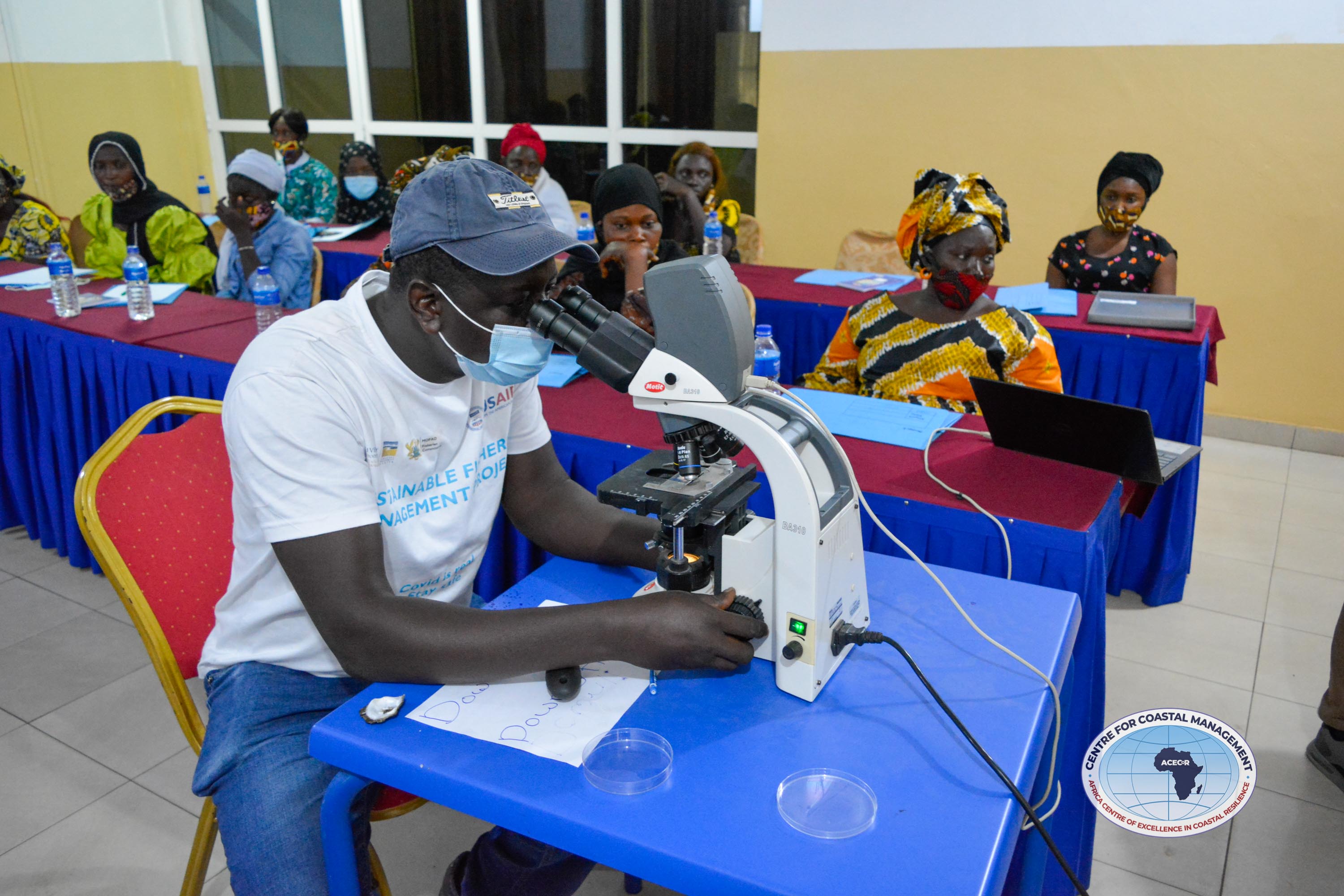 Trainer (Dr. Isaac Okyere) sets up microscope for demonstration